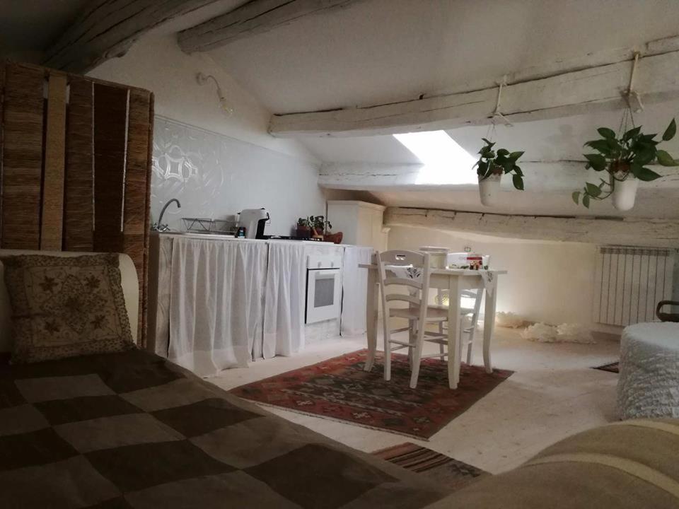 a living room with a table and a kitchen at sacrobosco apartment Pioppo in Bomarzo
