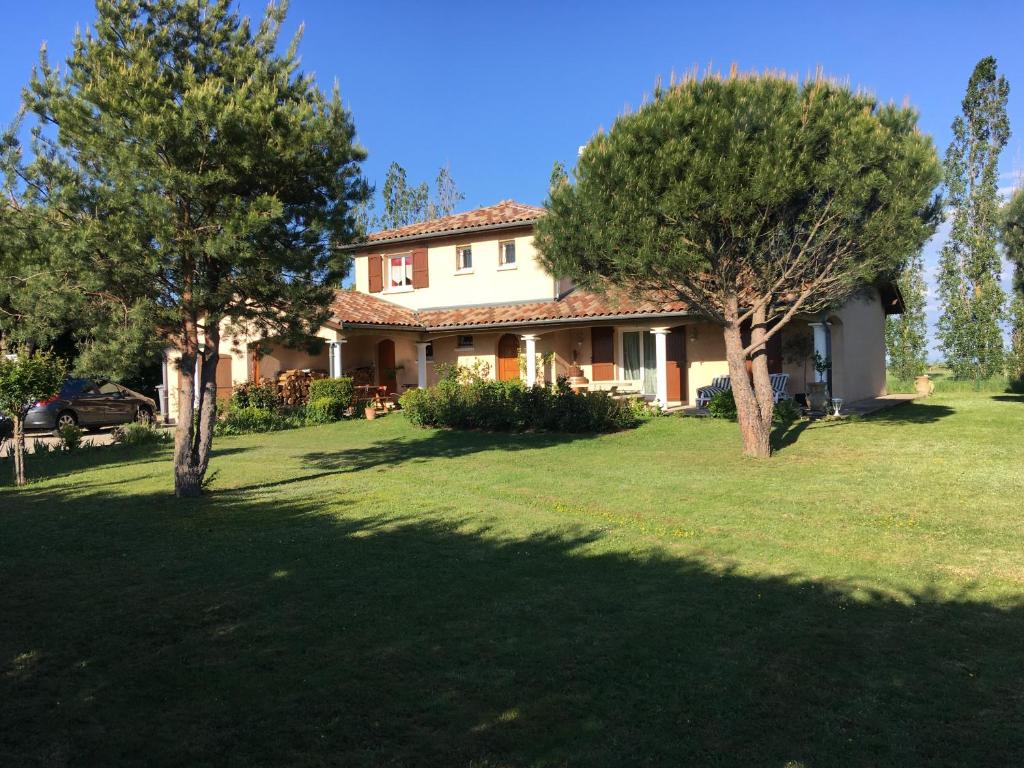 a house with trees in front of a yard at Le paradis de la Provence in Verenay