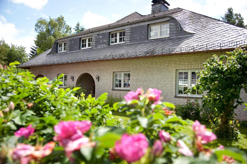 an old house with pink flowers in front of it at Eifel Relax in Hillesheim