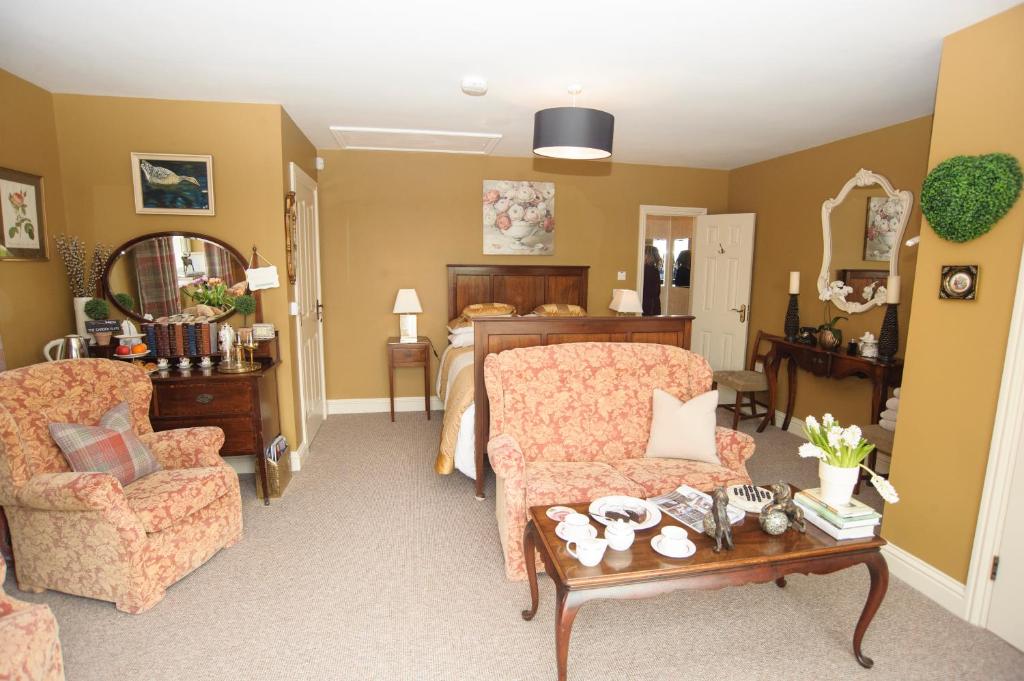 a living room with two chairs and a table at The Brown Hen Guest Accommodation in Bandon