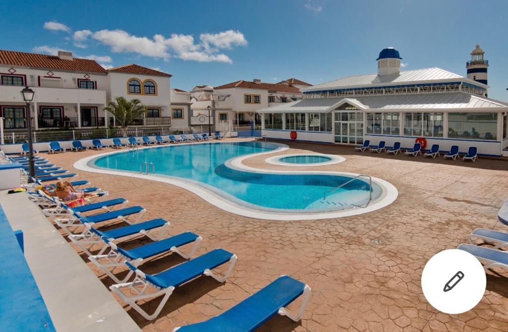 una piscina con sedie a sdraio e un resort di Mencey a San Miguel de Abona