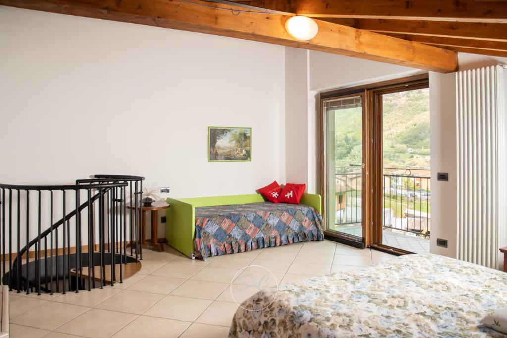 sala de estar con cama y balcón en Feel at Home - VILLA VERBENA, en Monasterolo del Castello