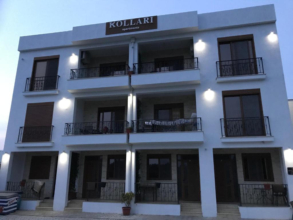 a white building with a sign on it at Kollari Apartments in Ulcinj
