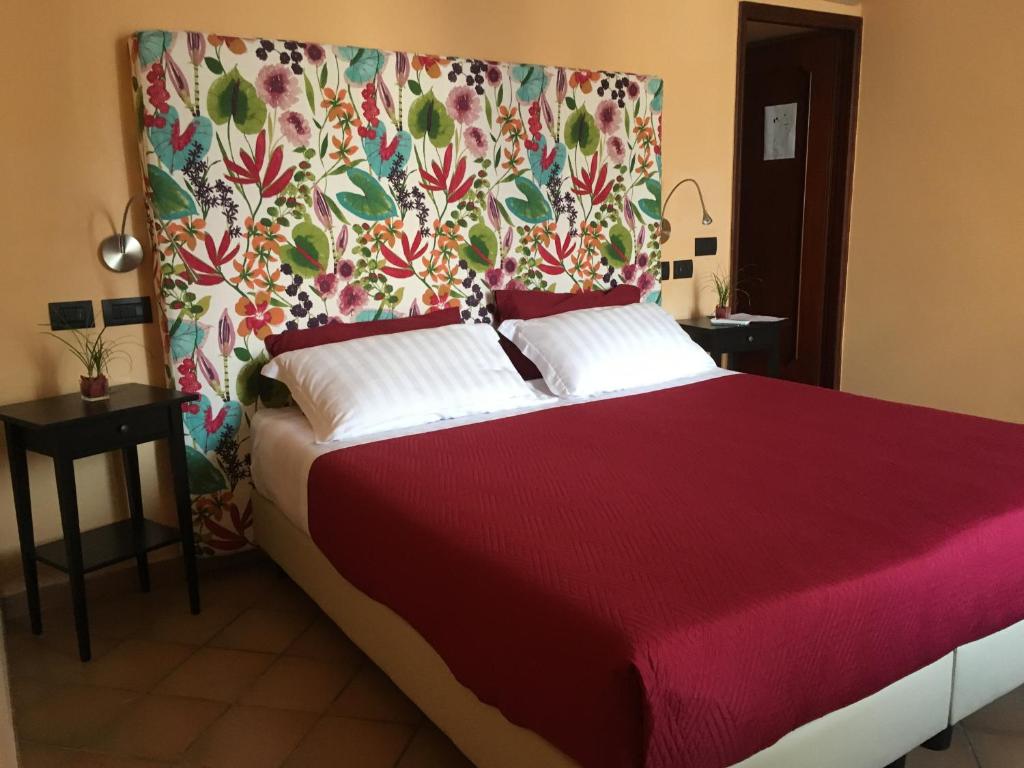 1 dormitorio con cama roja y cabecero de flores en Residenza Viviani en Sant'Agnello