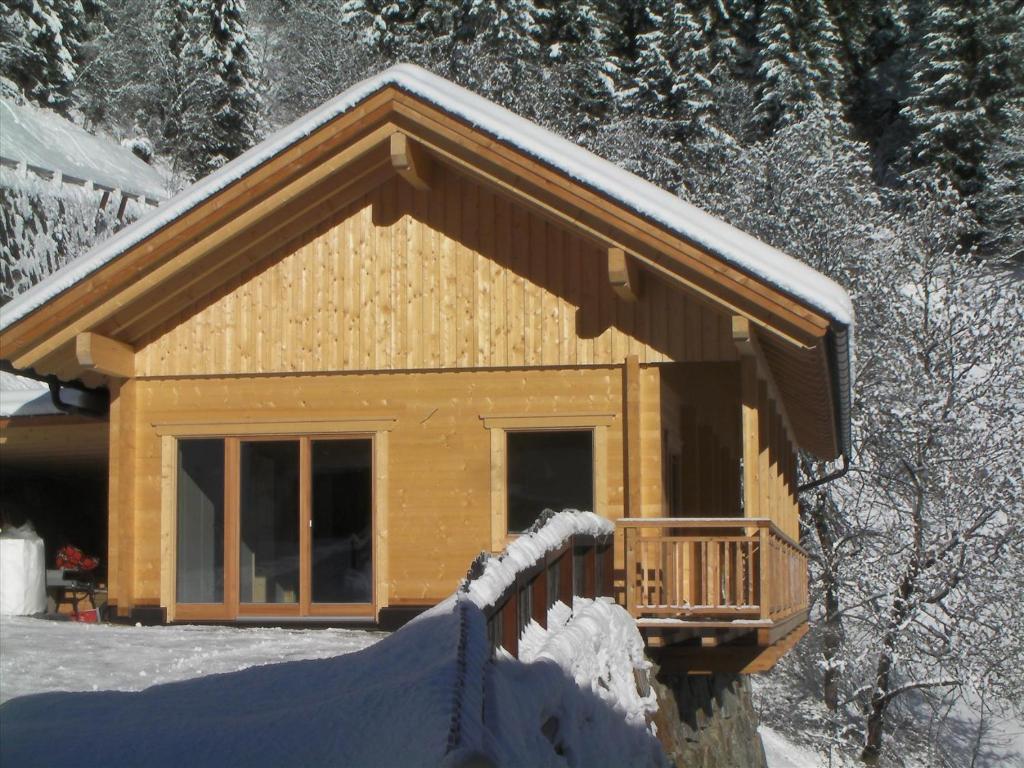 eine Blockhütte mit Schnee auf dem Dach in der Unterkunft Chalet Rasnerhof in Hopfgarten in Defereggen