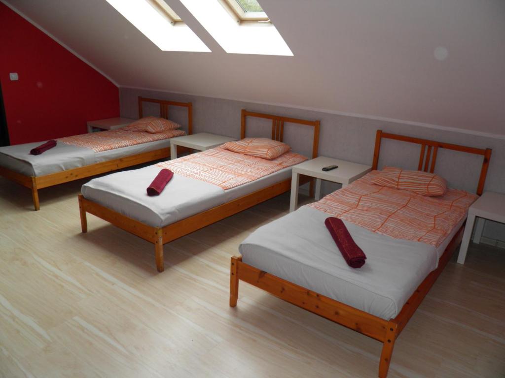 棟布羅瓦古爾尼恰的住宿－Marianki，一间设有三张床和红色枕头的房间