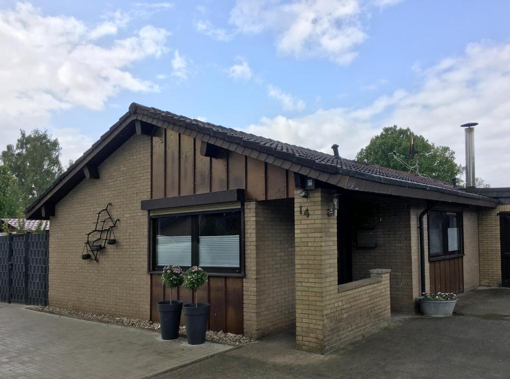 a brick house with two plants in front of it at Ferienhaus am See in Wettringen