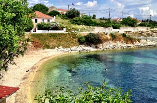 a beach with people swimming in the water at Kiki Studios in Fiskardo