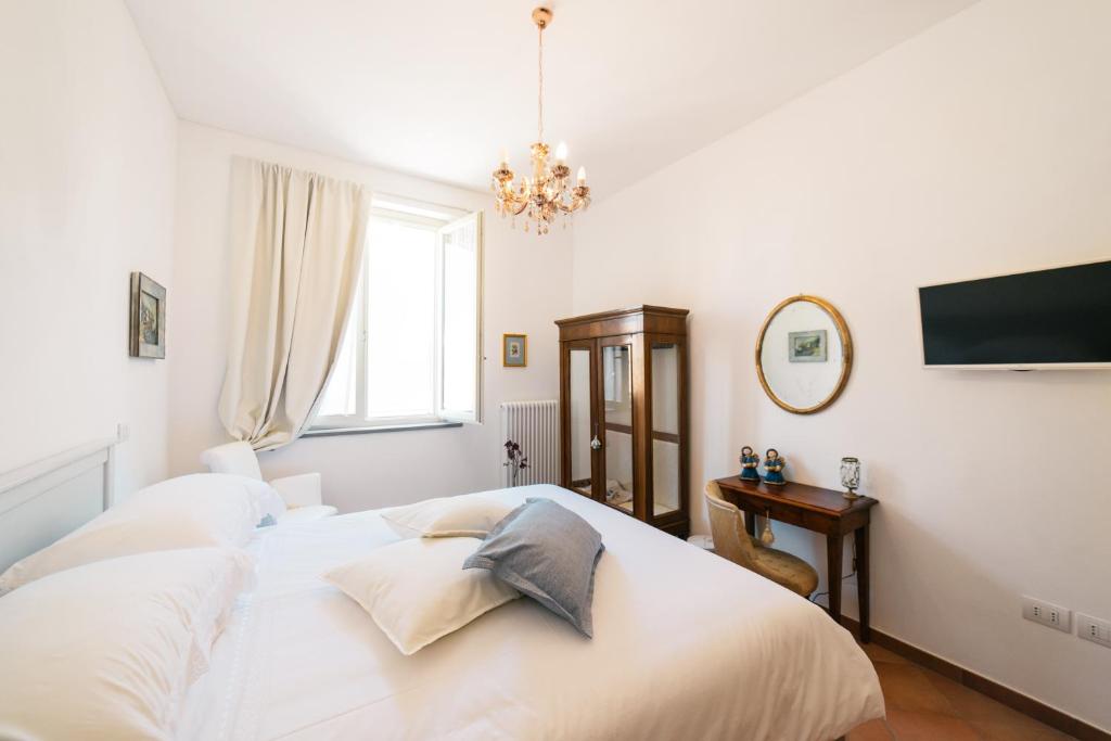 Habitación blanca con cama y escritorio en BB Porta Augustea - Fano en Fano