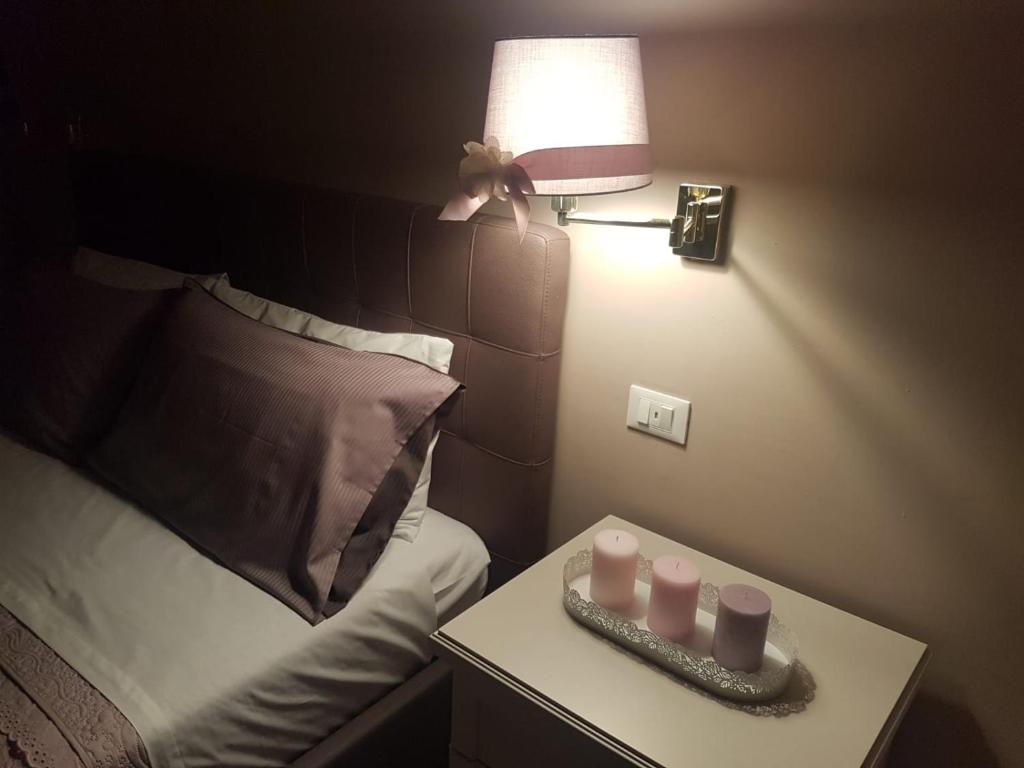 Habitación con cama y mesa con lámpara. en La Dimora del Falconiere - Luxury Suites, en Sulmona