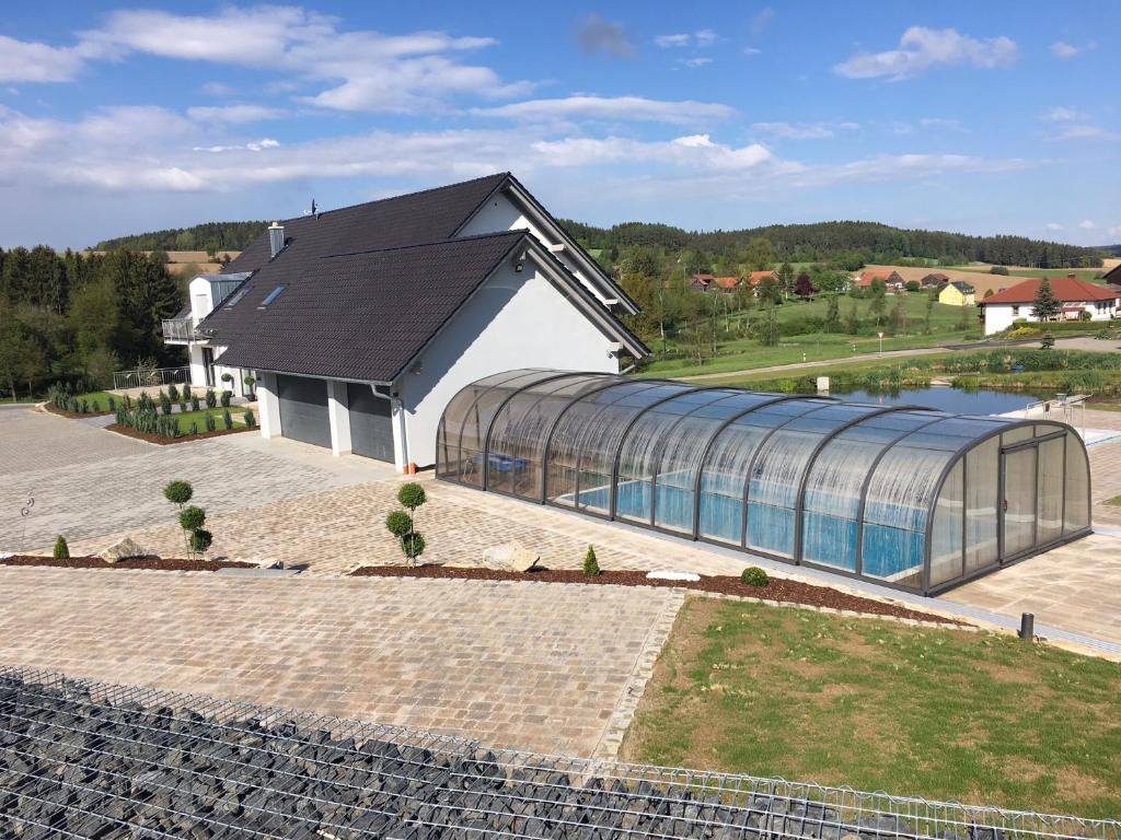 an image of a building with a glass greenhouse at Landhaus Ferienwohnungen mit Pool und Wellness in Neukirchen-Balbini