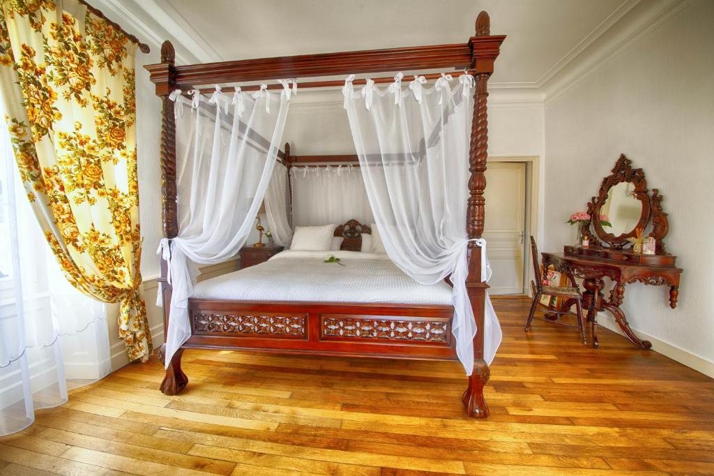 a bedroom with a canopy bed with white curtains at Maison d'hôtes de charme La Rose de Ducey près du Mont Saint Michel in Ducey