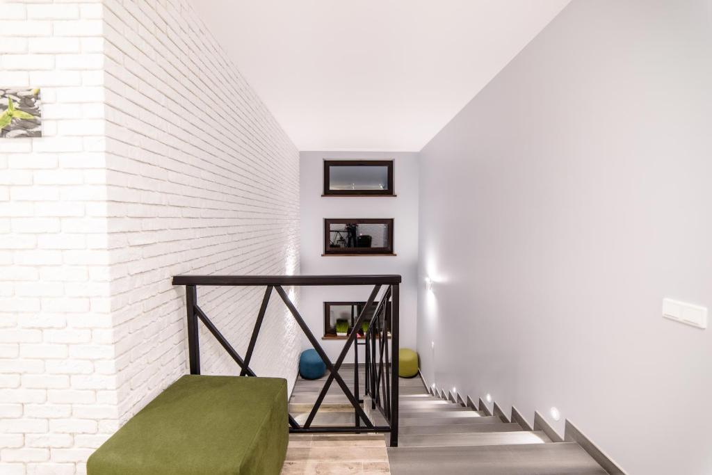 a staircase with a green ottoman next to a white brick wall at Is’land Hostel in Uzhhorod