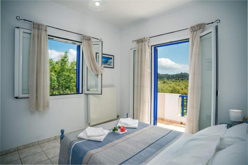 een slaapkamer met een bed en een groot raam bij Tsilivi Blue Vista Apartment in Tsilivi