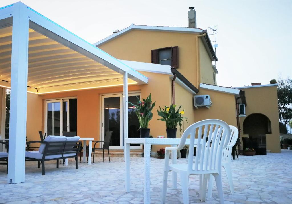 un patio con sillas y una mesa frente a una casa en B&B Fiori di Pesco en Fertilia