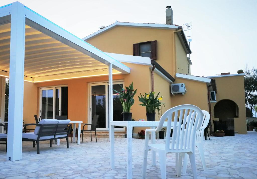 a patio with chairs and a table in front of a house at B&B Fiori di Pesco in Fertilia