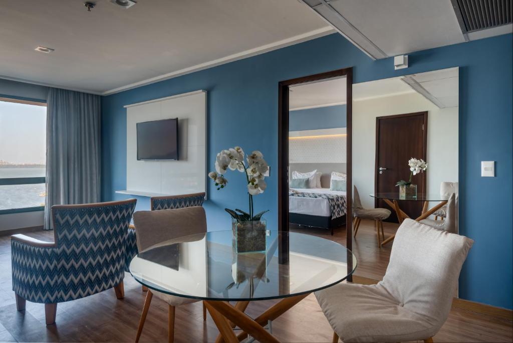 a living room with a glass table and chairs at Comfort Suítes Vitória in Vitória