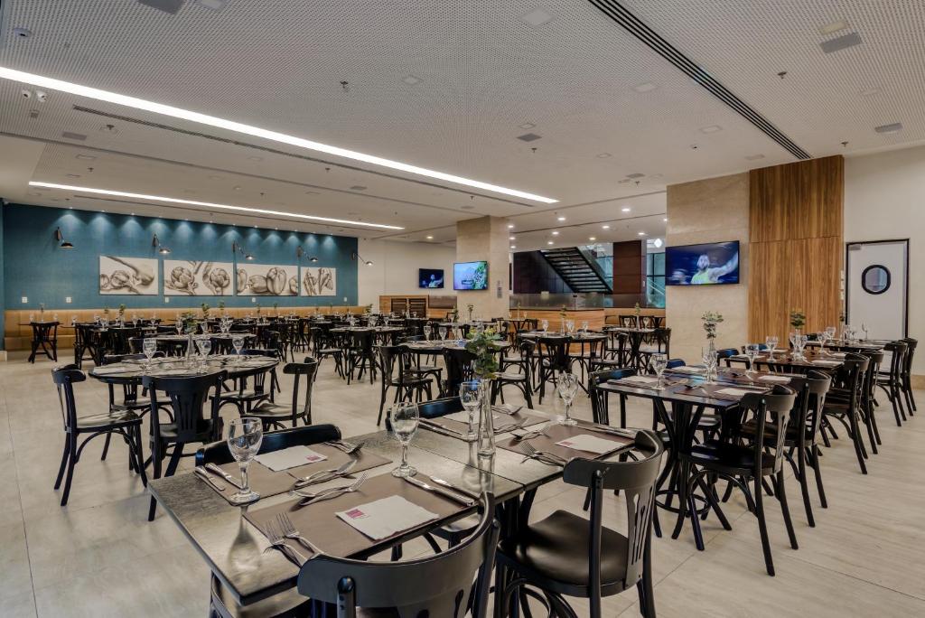 a dining room filled with tables and chairs at Comfort Suítes Vitória in Vitória