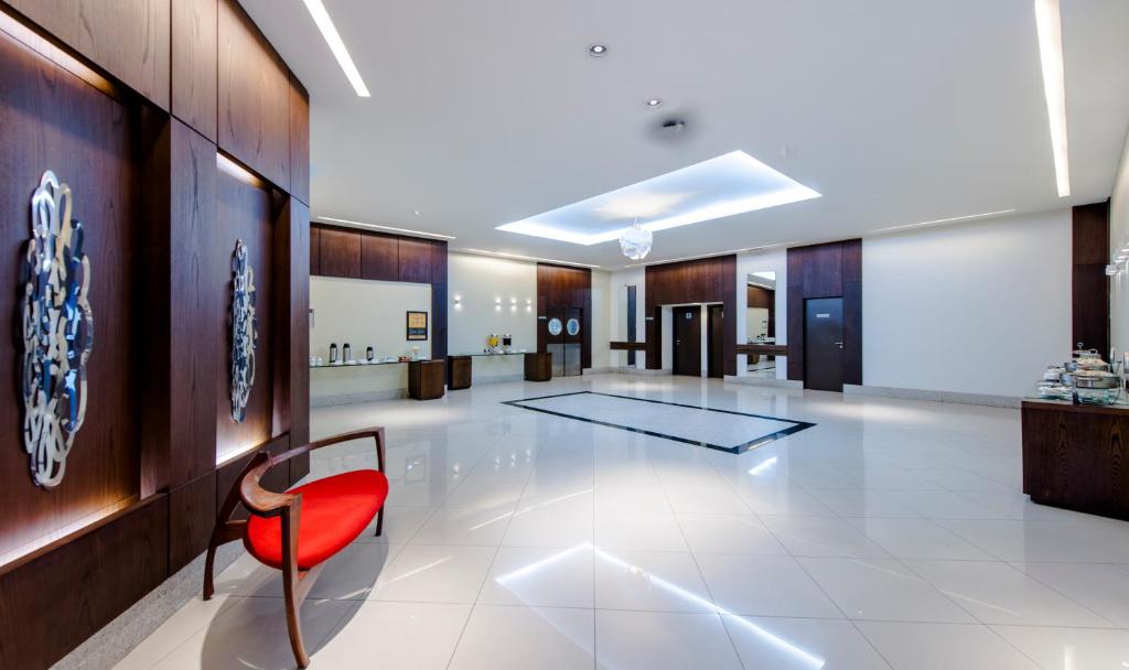 a lobby with a red chair in a building at Comfort Suítes Vitória in Vitória