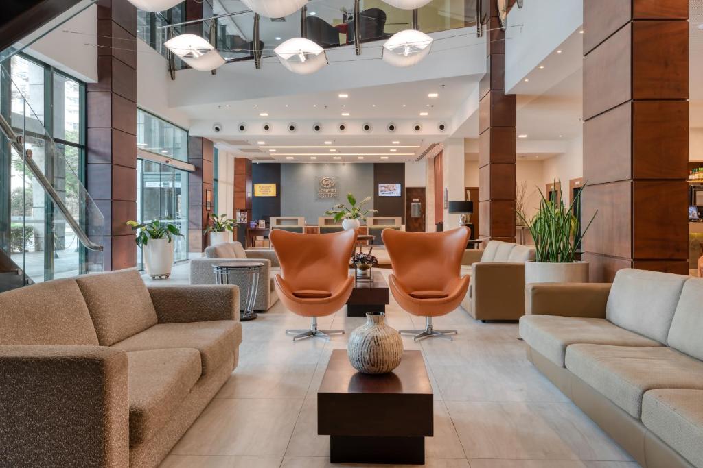 a lobby with couches and chairs in a building at Comfort Suítes Vitória in Vitória