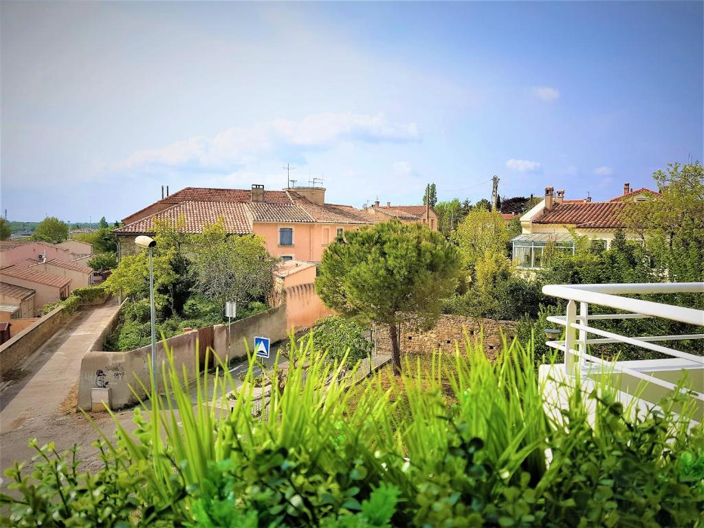uitzicht op een tuin met huizen en bomen bij Tout confort ! Climatisation, Calme, Piscine, Parking Gratuit, Terrasse, Wifi in Carcassonne