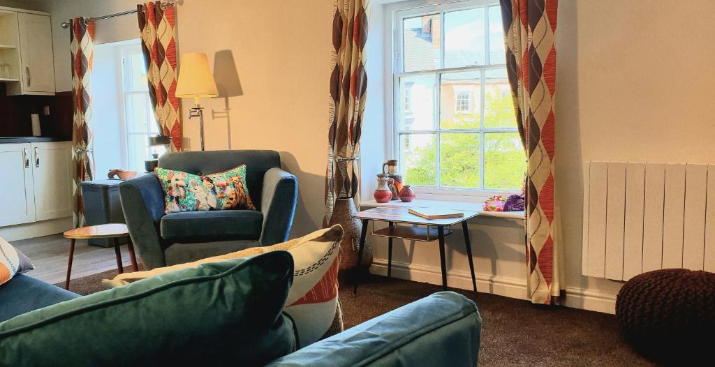 uma sala de estar com um sofá e cadeiras e uma janela em 20 Market Place Coleford em Coleford