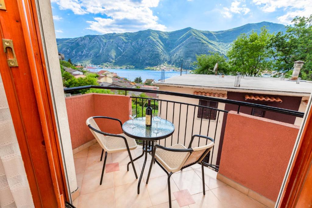 a balcony with a table and chairs and a view at Apartments Donkovic in Kotor