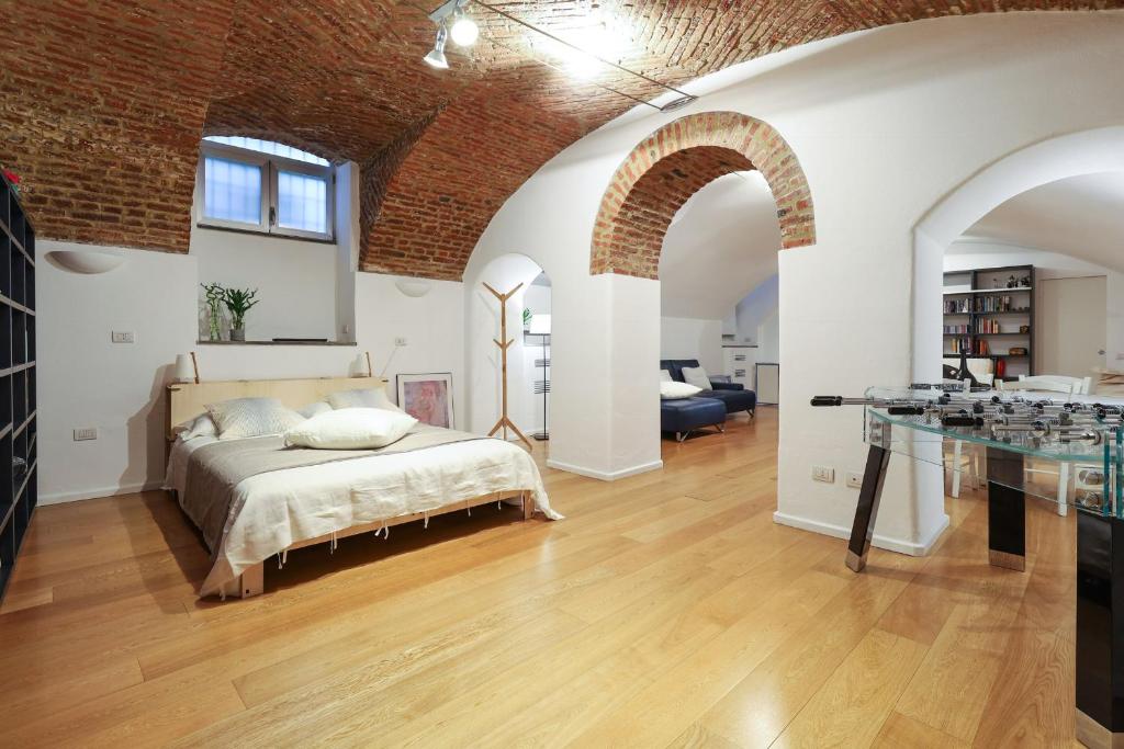 a bedroom with a bed and a brick wall at Luxury Loft in Milan