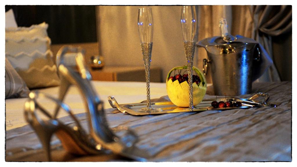 un tavolo con due bicchieri di vino e una tazza di ciliegie di Kristonia Hotel Suites a Kilkis
