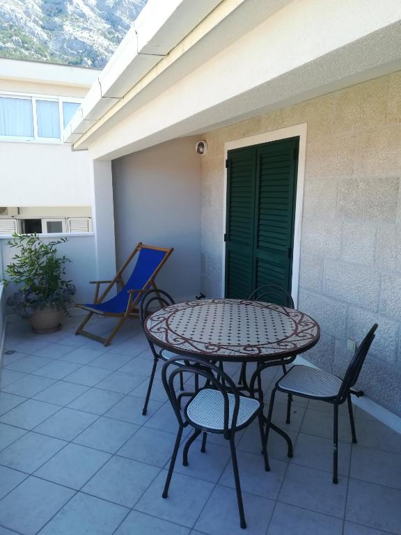 a patio with a table and chairs on a porch at Baška Voda - Apartmani Vesna in Baška Voda