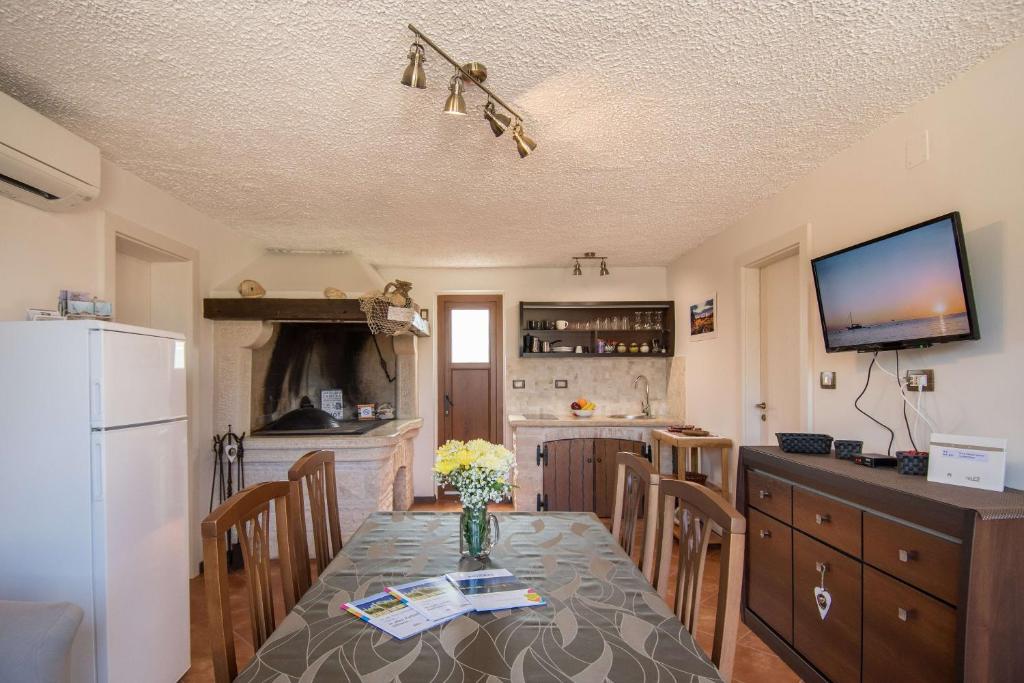 a kitchen with a table with chairs and a refrigerator at Alek in Novigrad Istria