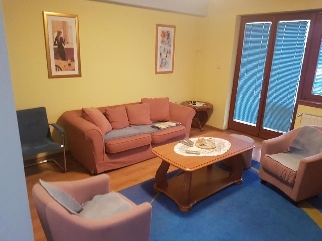 uma sala de estar com um sofá, cadeiras e uma mesa em GREEN and BLUE apartments em Banja Luka