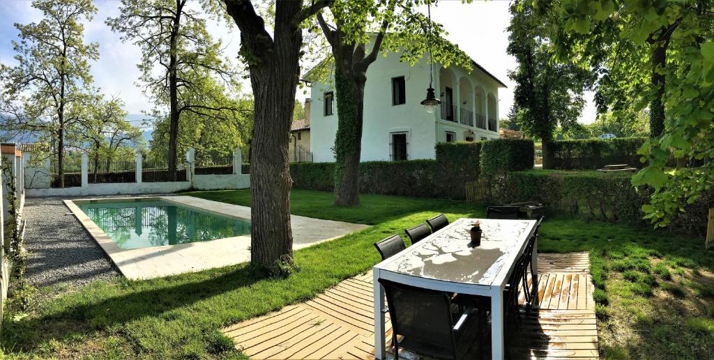 a backyard with a table and a swimming pool at TORRE de CODINAC in Sant Pere de Torelló