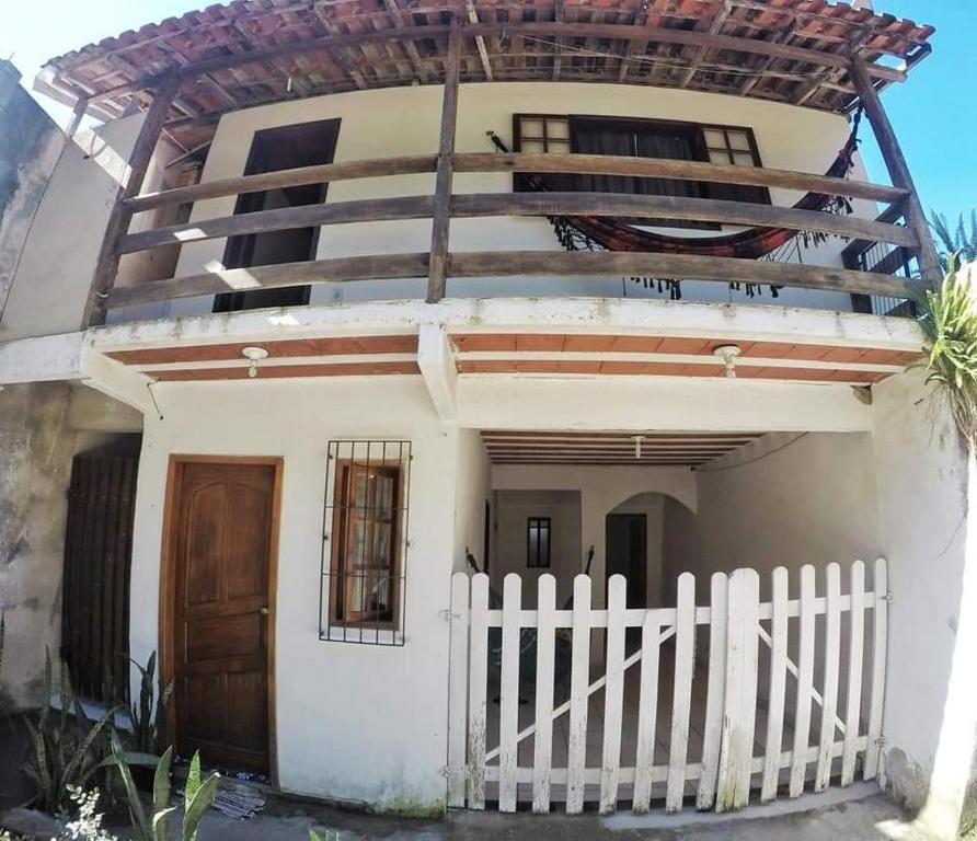 Casa blanca con puerta de madera y valla en Casa no Arraial do Sana en Sana