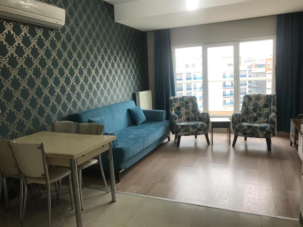 ein Wohnzimmer mit einem blauen Sofa und Stühlen in der Unterkunft Medıkule(8) 1+1 in Istanbul