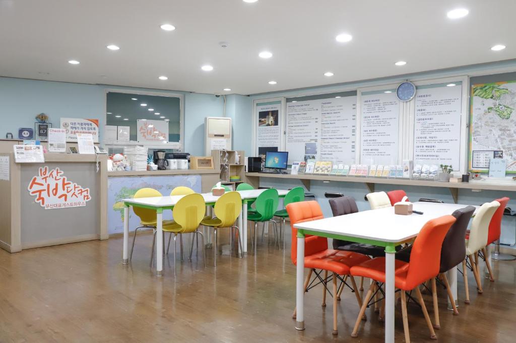 a restaurant with tables and chairs in a cafeteria at Busan Sukbak Dot Com Guesthouse in Busan