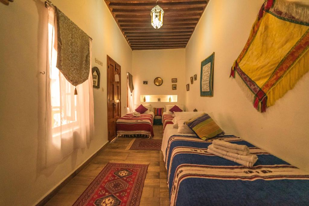 a hallway with three beds in a room at Riad Dari in Tetouan