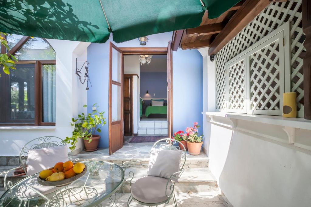 a patio with a glass table with a bowl of fruit at Alterra Vita in Neos Marmaras