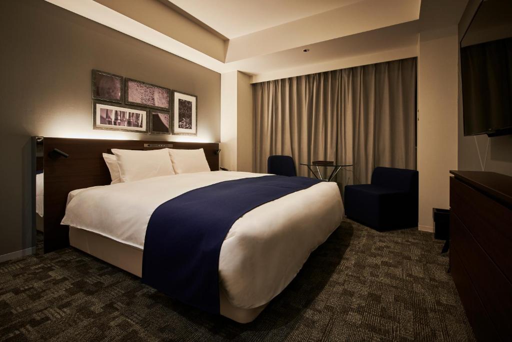 Postel nebo postele na pokoji v ubytování Cross Hotel Sapporo