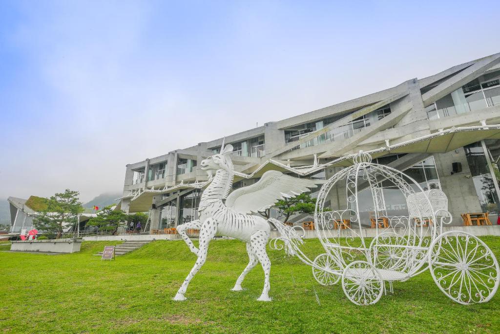 une statue d'un cheval tirant une calèche devant un bâtiment dans l'établissement Khokak Panoramas Hotel, à Gukeng