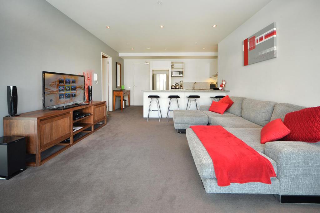 a living room with a couch and a flat screen tv at QV 2 Bedrooms Apartment Overlooking Marina -680 in Auckland
