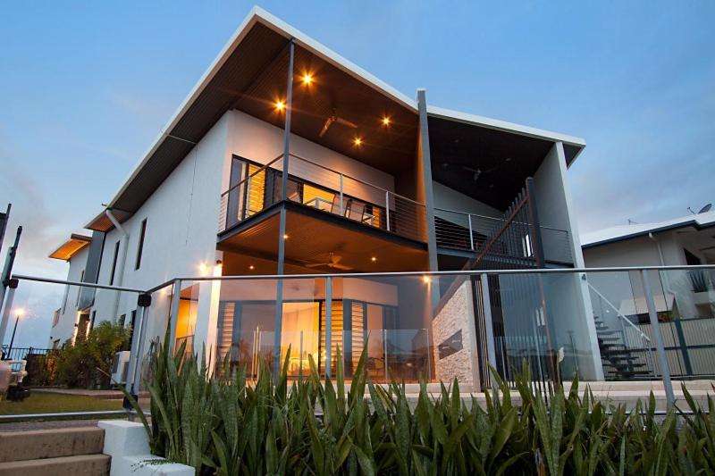 a large white house with a balcony with lights at Marina Views Townhouse in Darwin