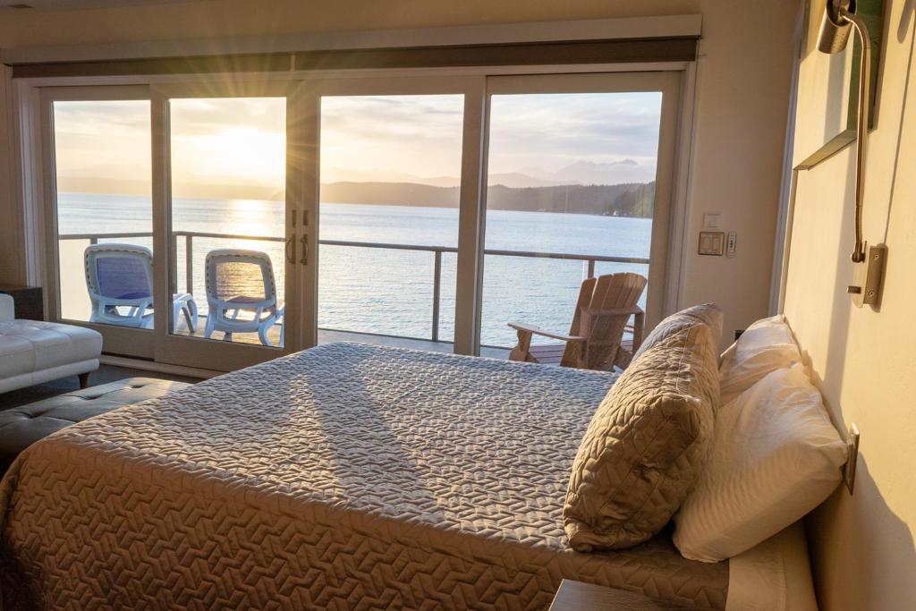 a bedroom with a bed with a view of the water at Luxury Lookout Hood Canal Vacation Rental in Union