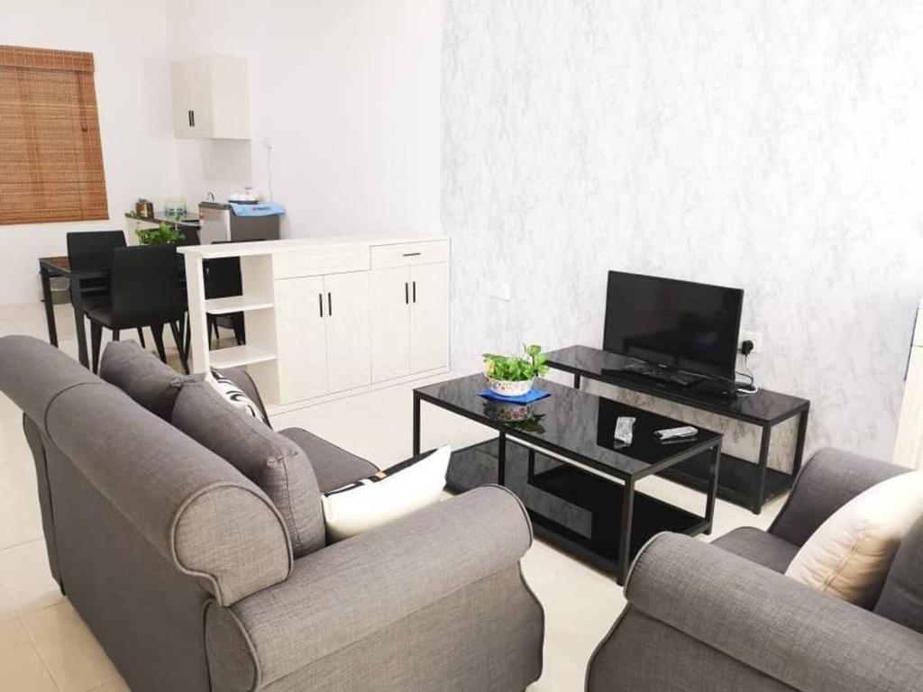 uma sala de estar com sofás e uma televisão de ecrã plano em Cozy 3 Bedrooms Apartment Langkawi em Kuah