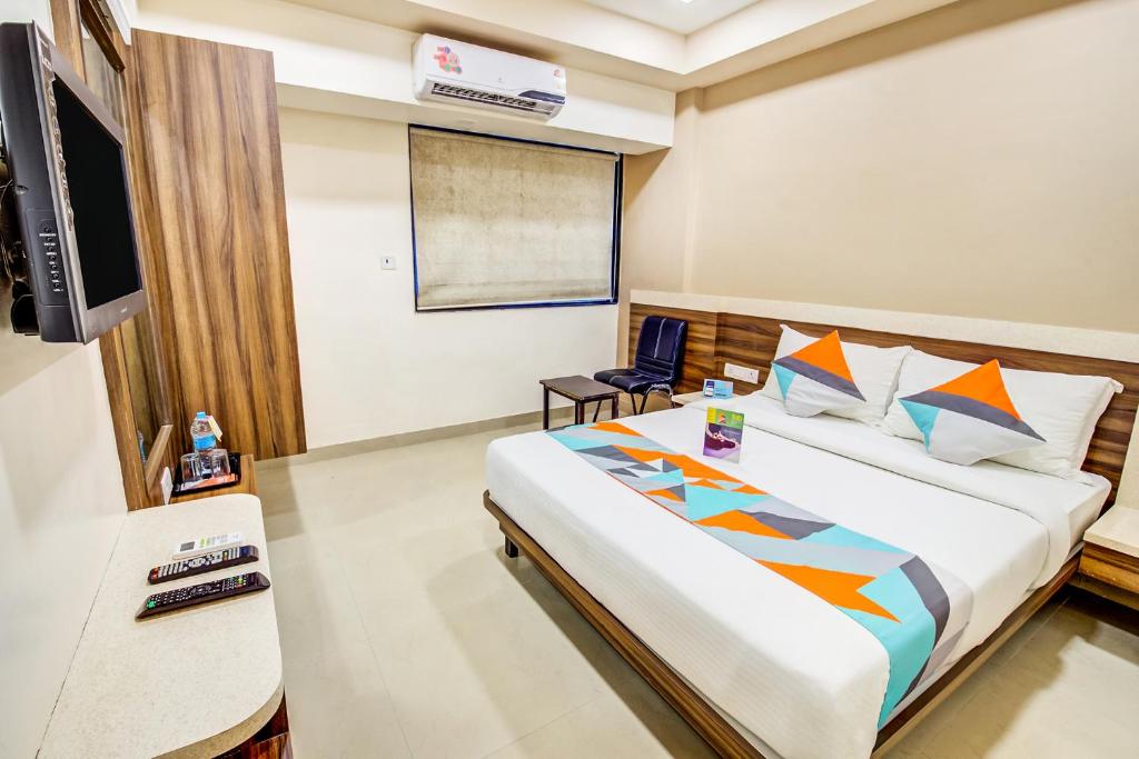 Habitación de hotel con cama y TV en Hotel Dreamland en Lonavala