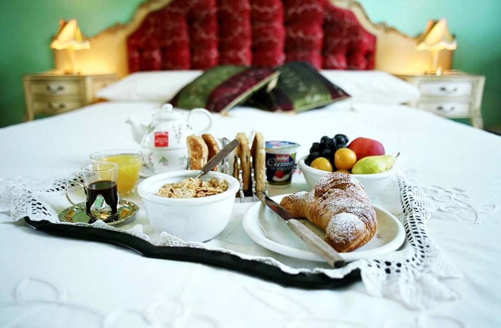 a breakfast tray with breakfast foods on a bed at 5 Balconi B&B in Catania