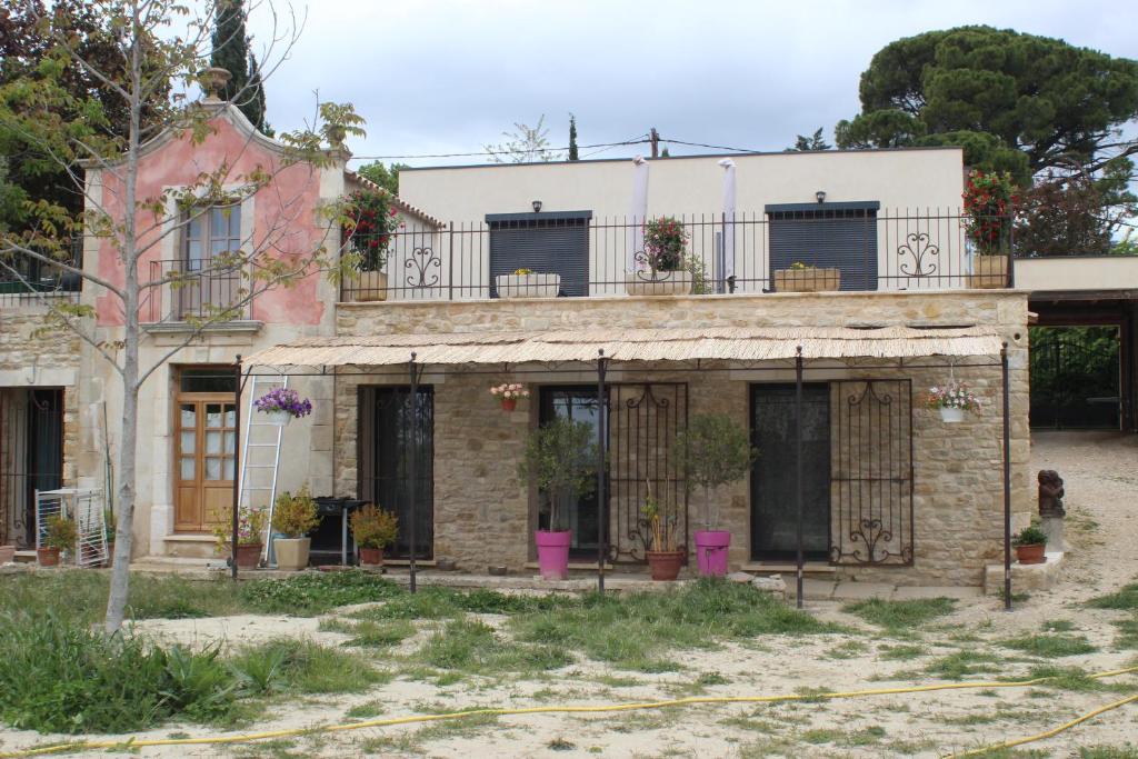 Una casa antigua con un balcón encima. en Le Bastidon de CUCURON, en Cucuron