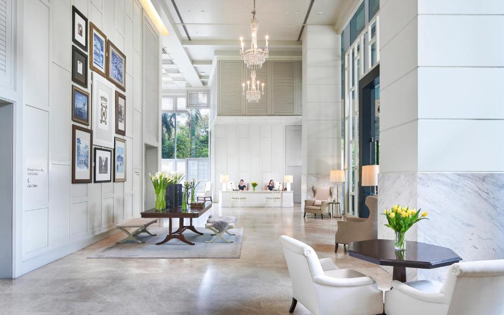 A high-ceilinged lobby with chandeliers, art displays, and small seating areas.