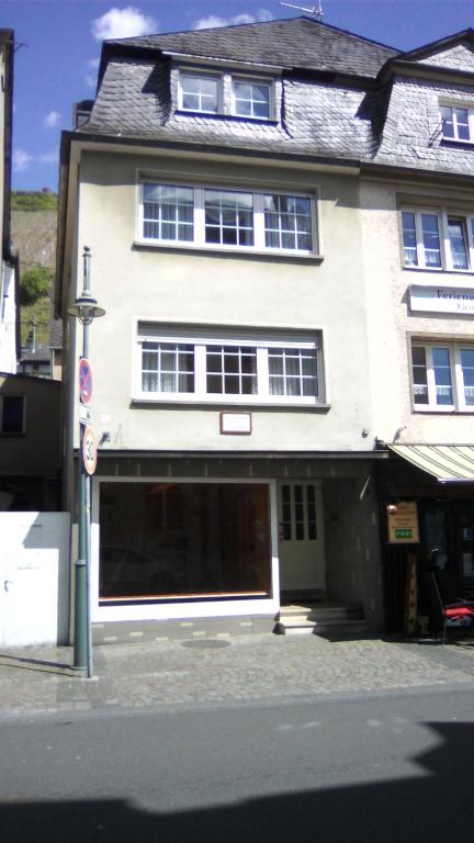 a large white building with a garage on a street at mosel ferienwohnung in Zell an der Mosel
