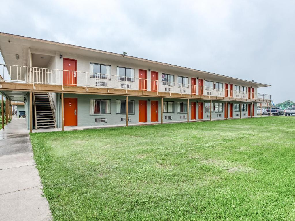 ein Gebäude mit roten Türen und einem großen Hof in der Unterkunft OYO Hotel San Antonio East in San Antonio